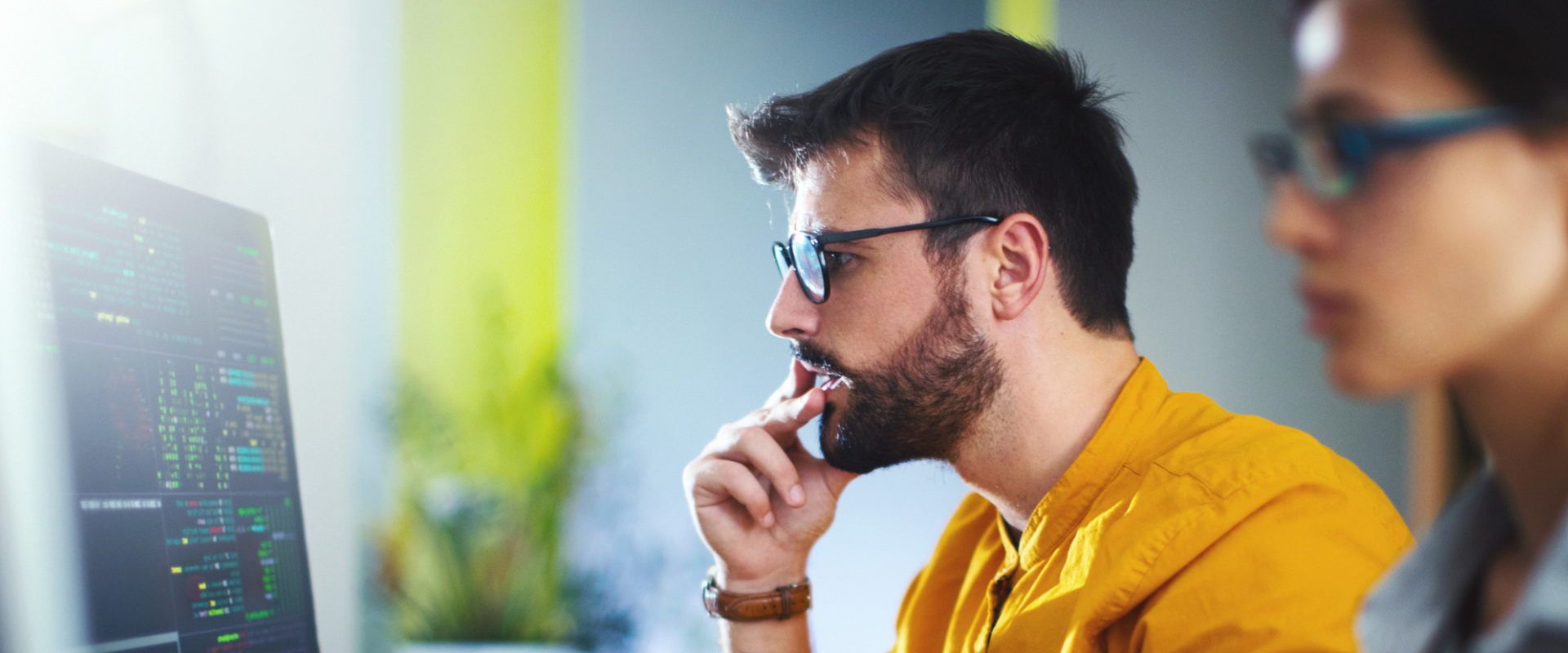 Man looking at computere screen with programming code