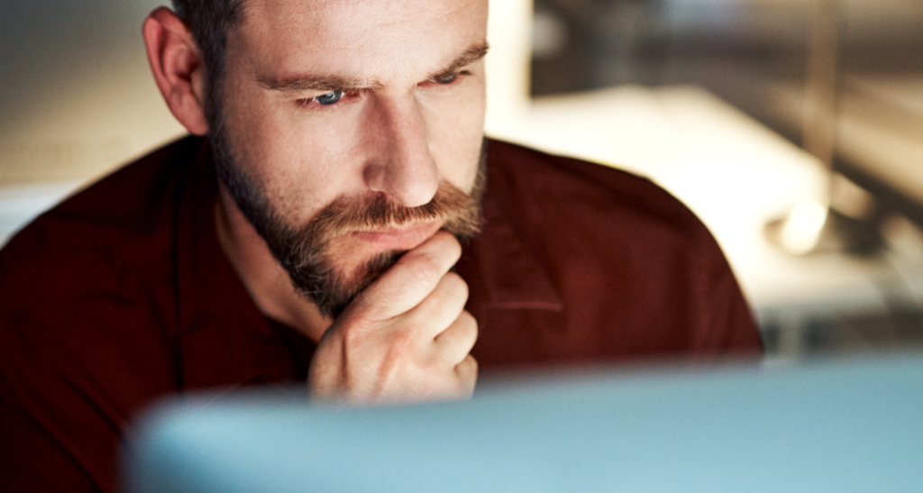 Man looking at his computer screen, thinking