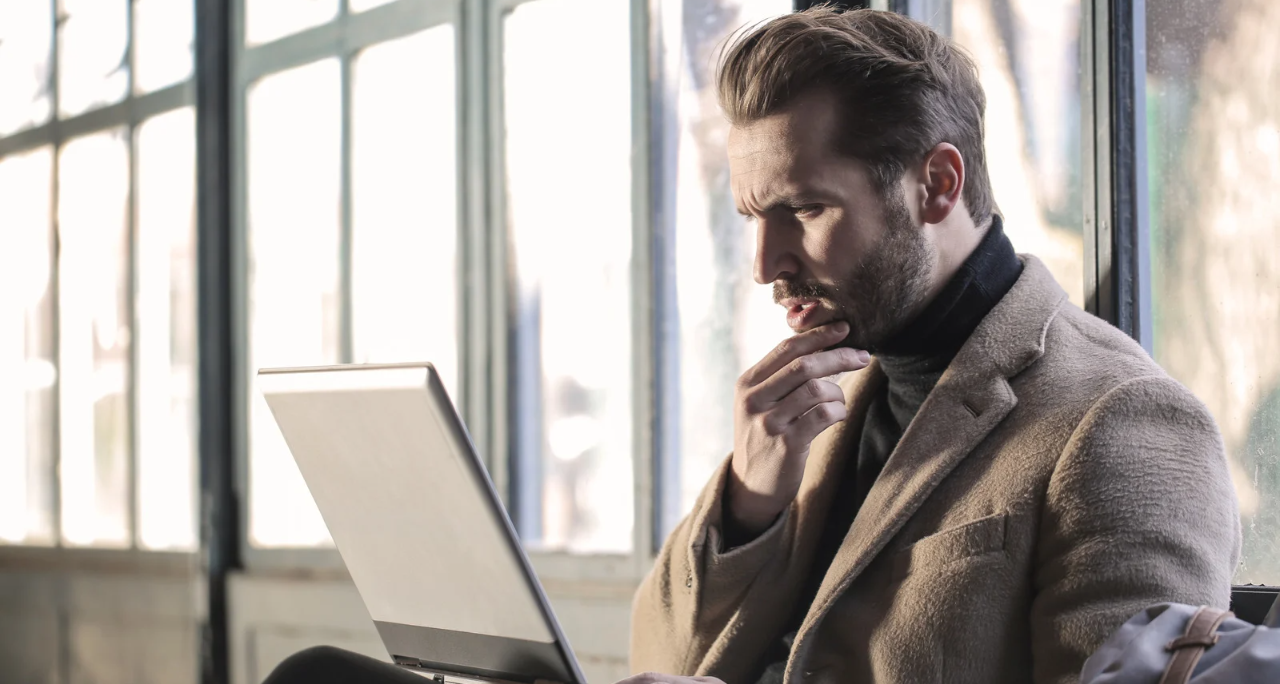 Man thinking with computer is his lap